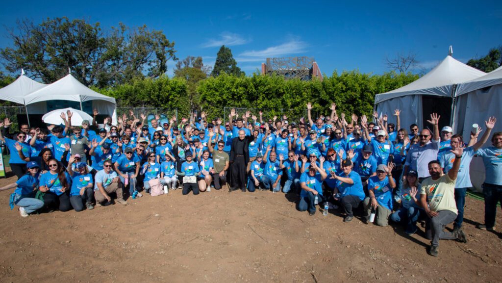 Monseñor Lloyd Torgerson, al centro, junto a voluntarios de la Coalición Católica local de Habitat for Humanity el 26 de septiembre, en el lugar donde estaba Corpus Christi, en Pacific Palisades. Torgerson dirigió una oración y bendición especial antes de que los voluntarios comenzaran a trabajar. (Mike Goulding)
